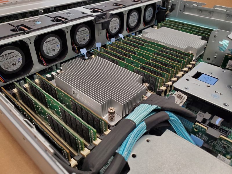 An open server chassis on a table: a row of fans, banks of memory and a large heatsink being fitted.