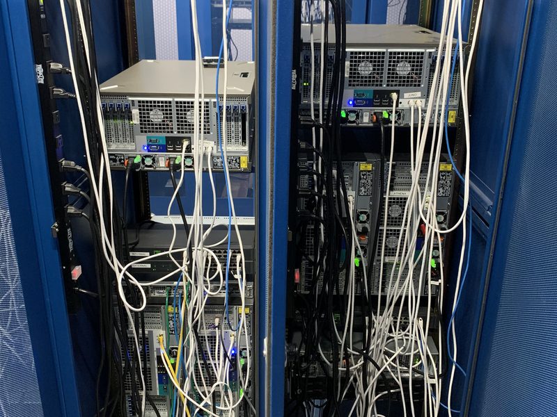 The inside of a blue cabinet: servers racked and cabled.